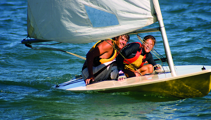 brother and sister sailing in small dinghy