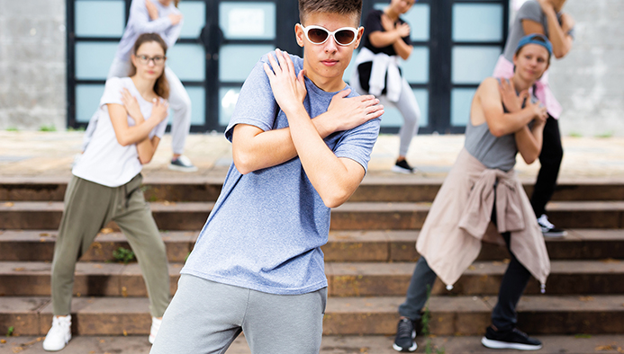 teen boy dancing modern street dance with teenagers