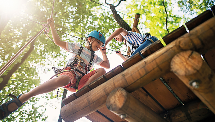 feriencamp - little girl helping her brother on ropes course